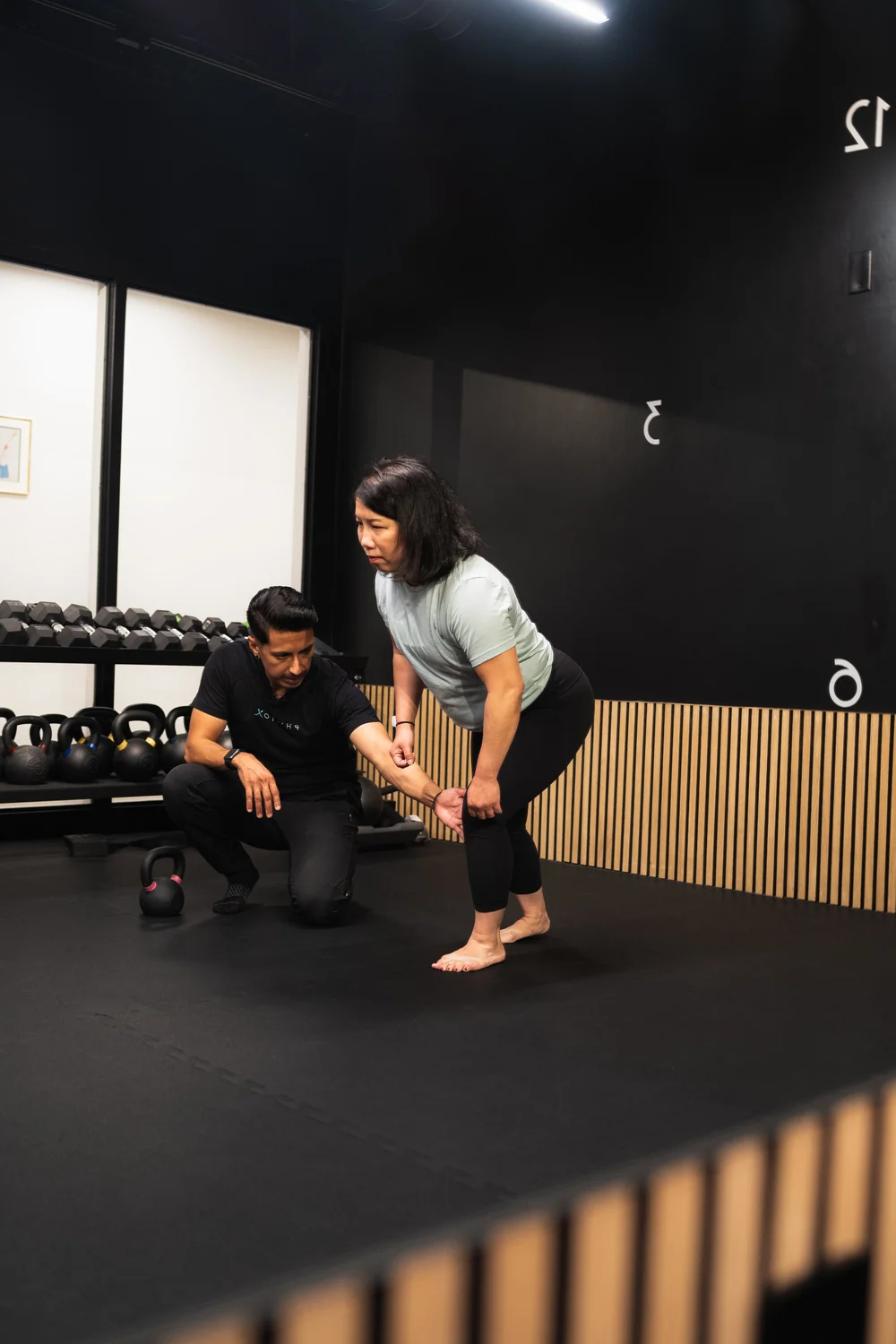 Coaching a single-leg balance exercise at PhyziX