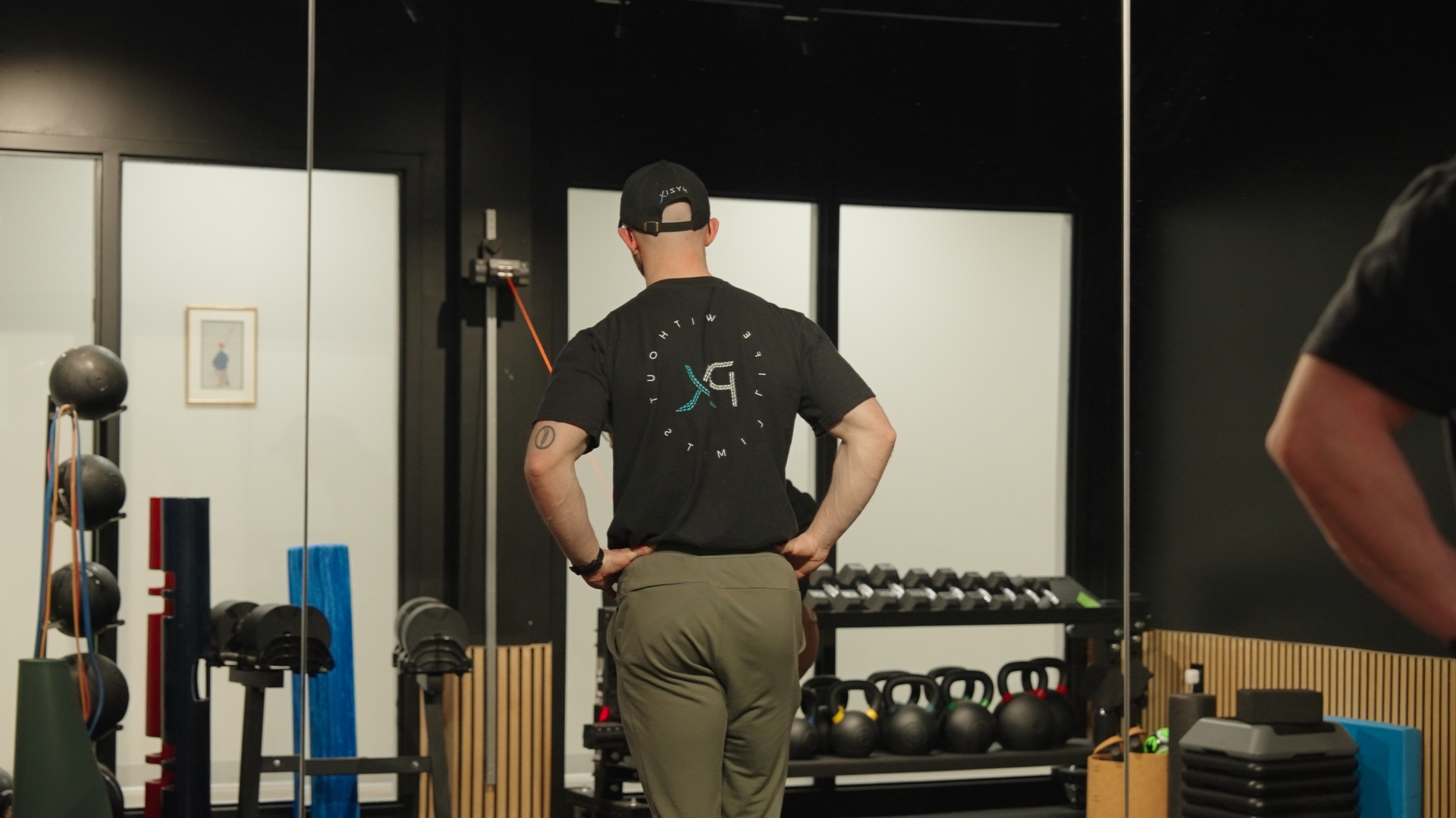 Physical therapist coaching a client through a cable exercise in the PhyziX gym